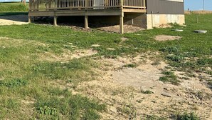 A two-story building with a balcony and a covered porch area. - Welcome to The Fox Farm cabin  (Genoa)