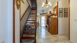A staircase leading to a second floor, a chandelier, and a dining area with a table and chairs. - Marina Beach in Fuengirola (Fuengirola)