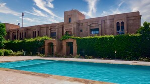 Une piscine avec un bâtiment en arrière-plan.