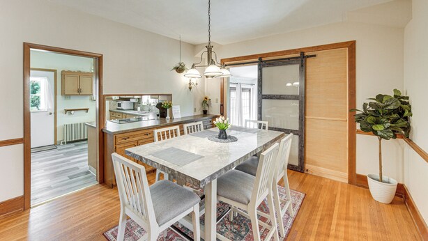 A dining area with a marble table, grey cushioned chairs, a chandelier, and a potted plant. - 5 Mi to Hersheypark: Family Home w/ Game Room (Annville)