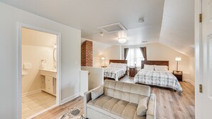 A bedroom with two beds, a sitting area with a sofa, and a bathroom with a sink and mirror. - 5 Mi to Hersheypark: Family Home w/ Game Room (Annville)