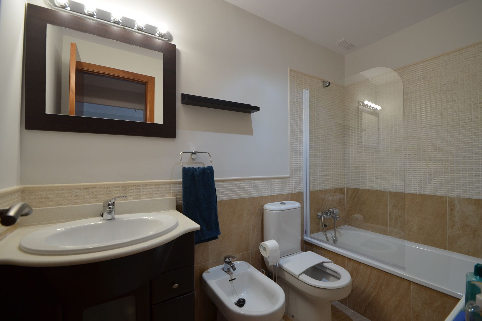 A bathroom with a sink, bidet, toilet, and bathtub.