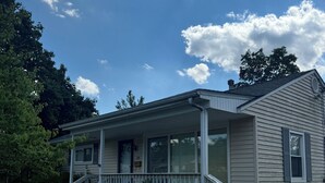 A single-story house with a front porch, a garage, and a small front yard. - The Salon- 3 miles from WEC (Wilmington)