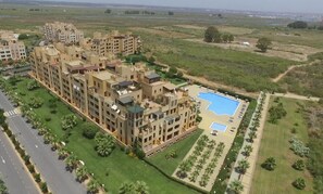 Residents enjoy a central pool surrounded by lush greenery and palm trees.