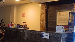 A reception desk with a sign indicating a reception area, a calendar, and some items on the counter. - Hotel Jhonyky (Bucaramanga)