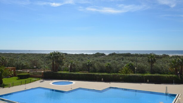 A rectangular pool with a circular center, surrounded by a paved deck. - Los Pelicanos 94 - Two Bedroom Apartment, Sleeps 5 (Punta del moral)