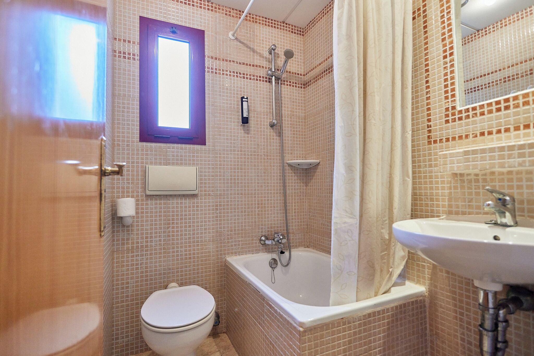 A bathroom with a toilet, a bathtub, and a sink.