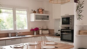 Una cocina moderna con una mesa de comedor de madera, armarios blancos y un horno empotrado.