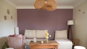 Una sala de estar con un sofá, una mesa de centro y una lámpara.