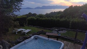 A hot tub on a wooden deck with a view of a lake and mountains in the background. - Cinque Terre breakfast home with optional access to Pool, Sauna and Jacuzzi (SARZANA)