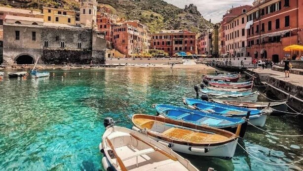 A coastal town with clear waters, boats docked along the waterfront, and historic buildings. - Cinque Terre breakfast home with optional access to Pool, Sauna and Jacuzzi (SARZANA)