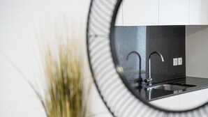 A modern kitchen with a stainless steel sink and a black countertop.