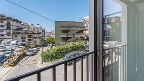 A balcony with a view of a parking area and buildings.