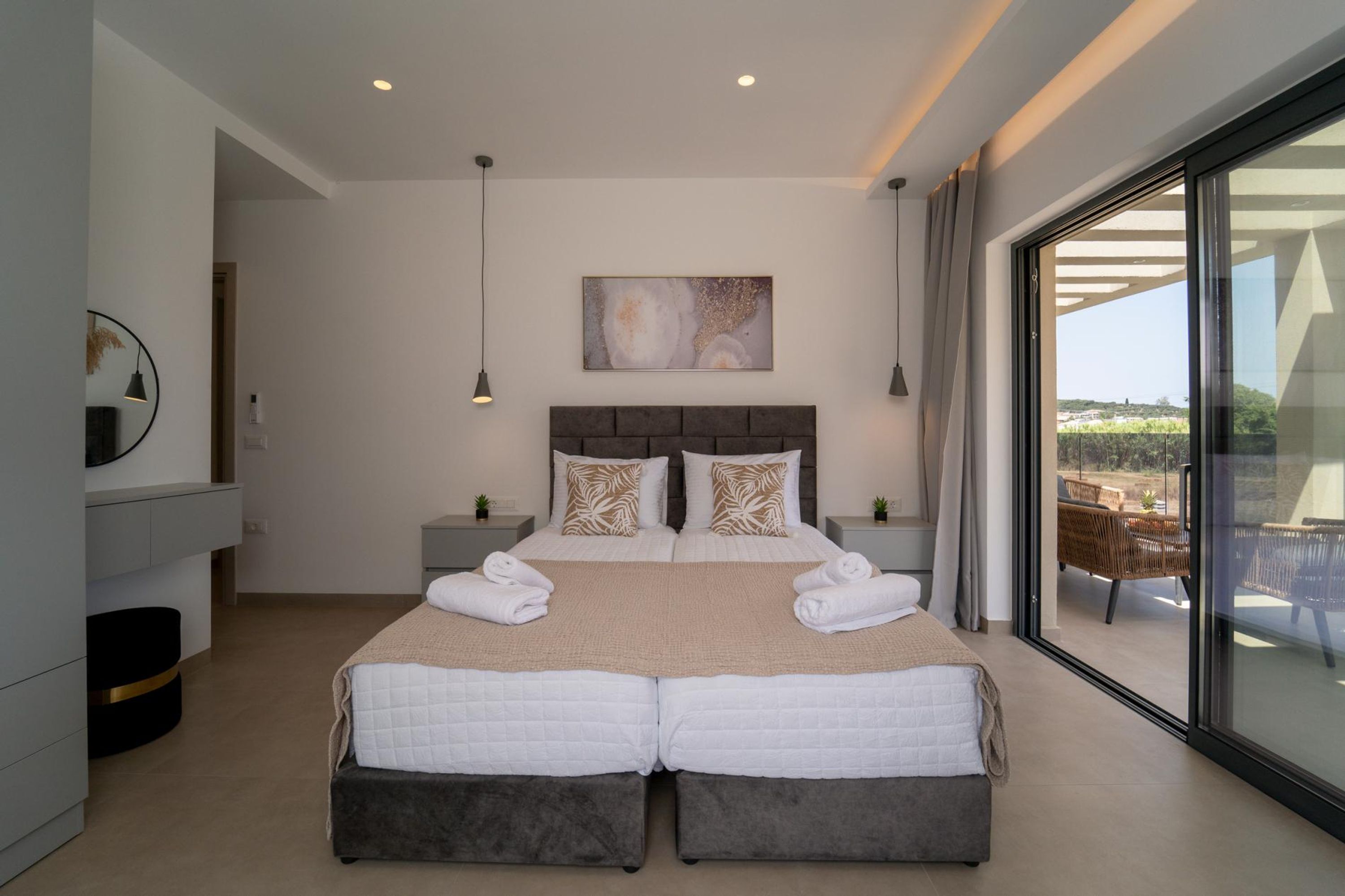 A modern bedroom with a large bed, a view of the outdoors, and a minimalist design.