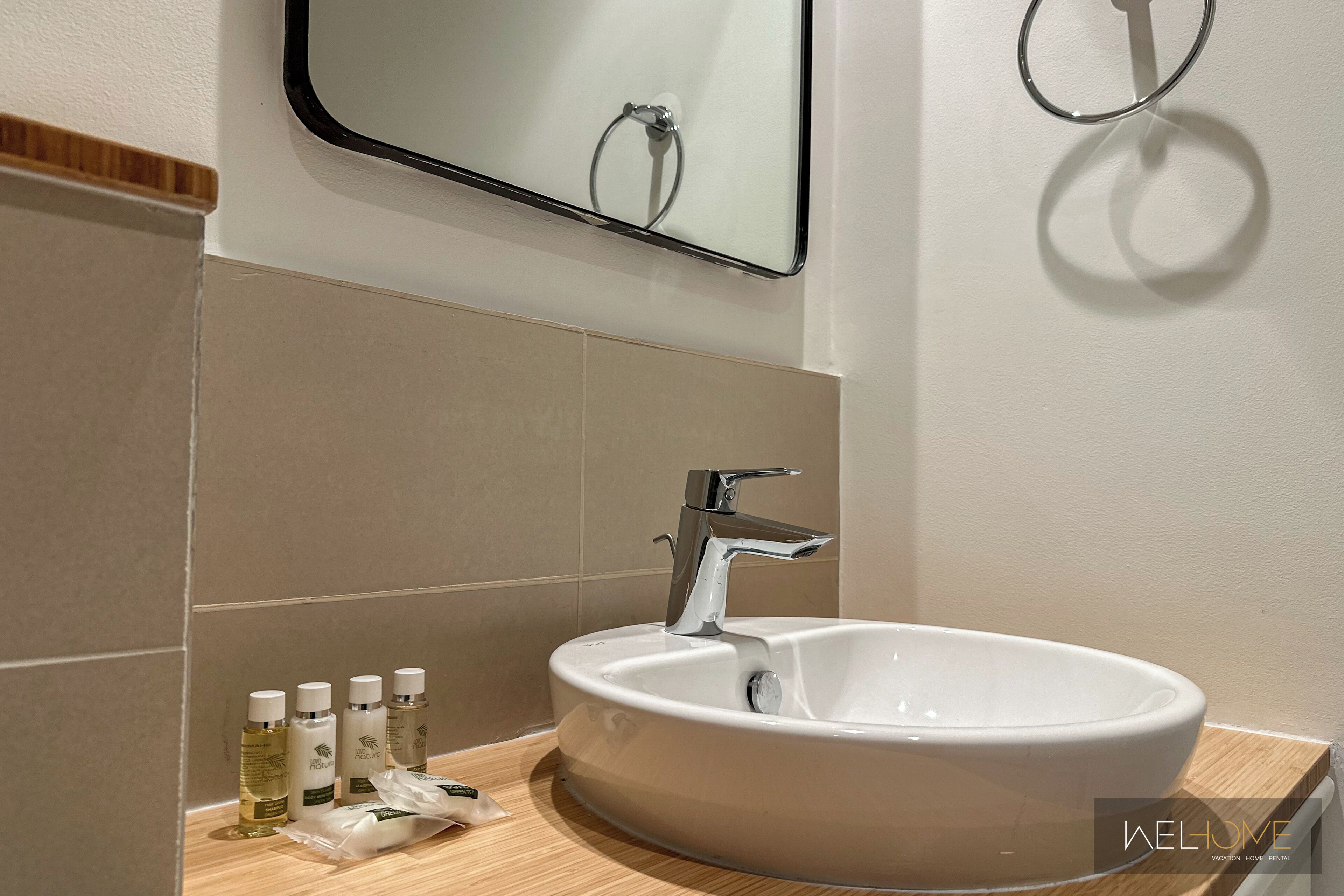 Une salle de bain moderne avec un lavabo blanc, un miroir et un porte-serviette.