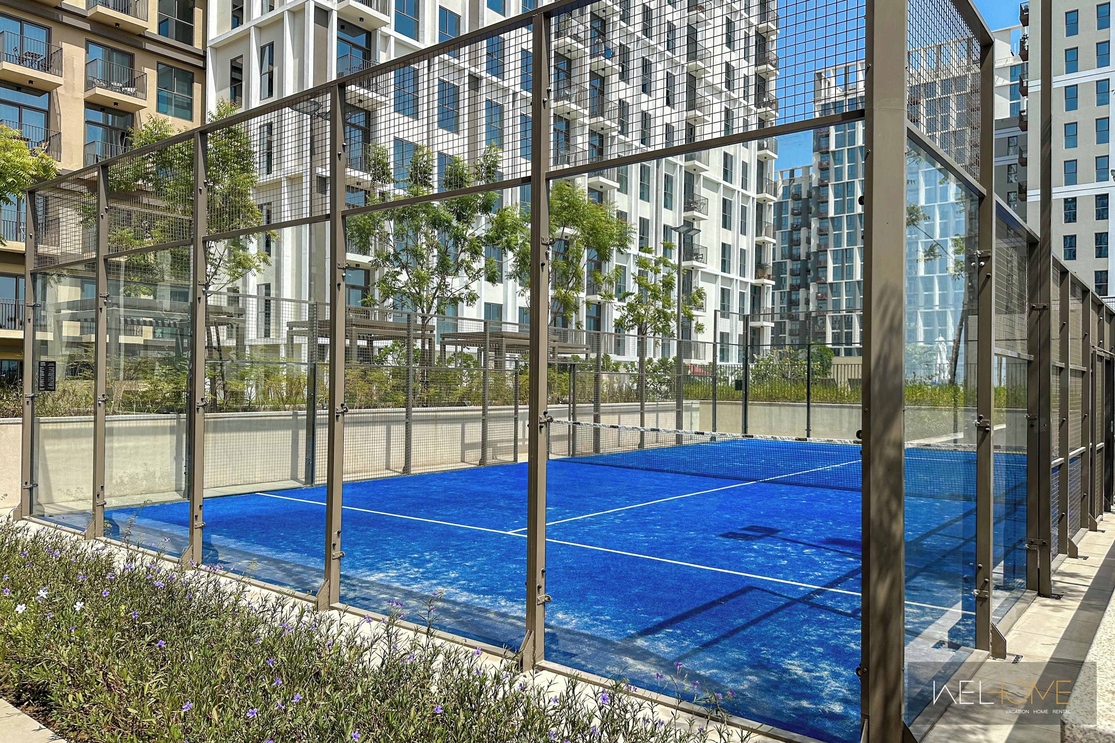 Une piscine sur le toit, protégée par une structure en verre, entourée d’immeubles modernes.