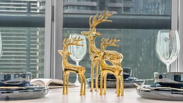 A table set with gold deer figurines, clear glassware, and black plates.