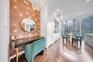 Una cocina moderna con protector mural de madera, un espejo redondo y un comedor con mesa y sillas.