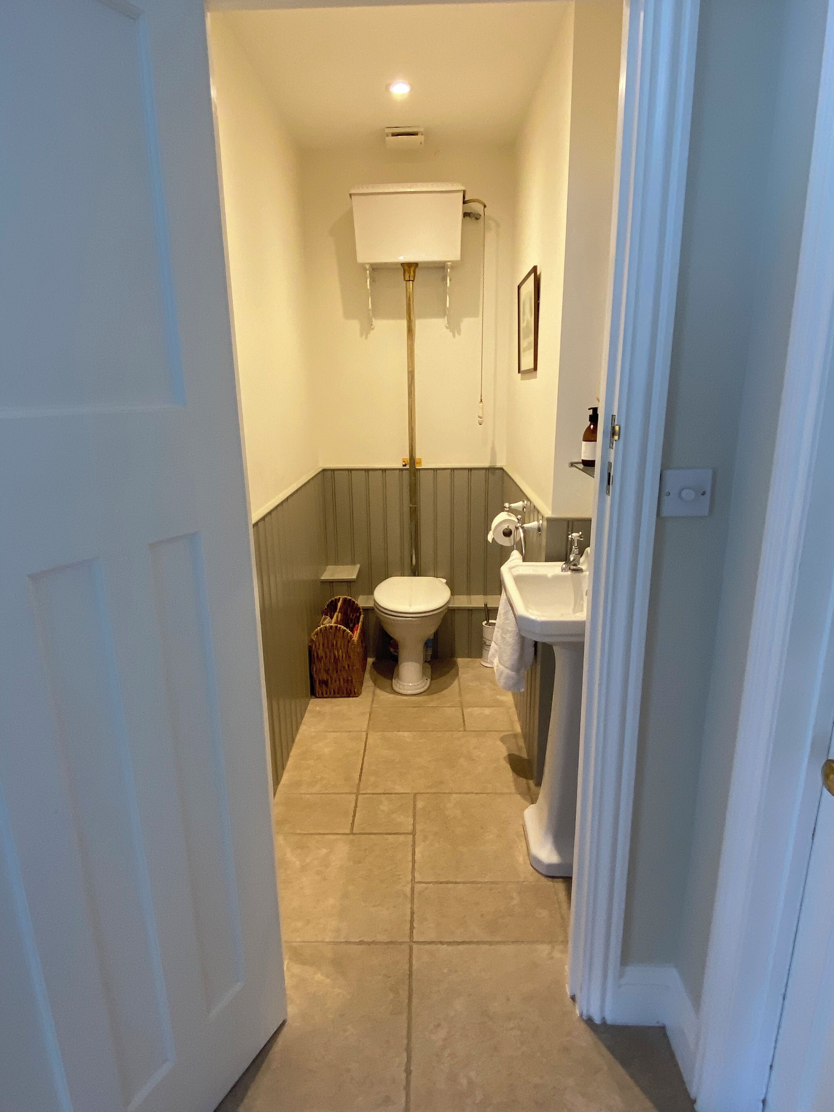 A bathroom with a toilet, sink, and a shower area.