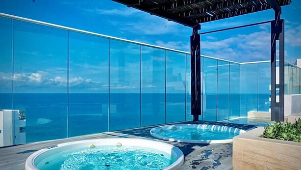 A rooftop terrace with two hot tubs and a clear view of the ocean. - Reserva del Mar Apartamentos (Santa Marta)