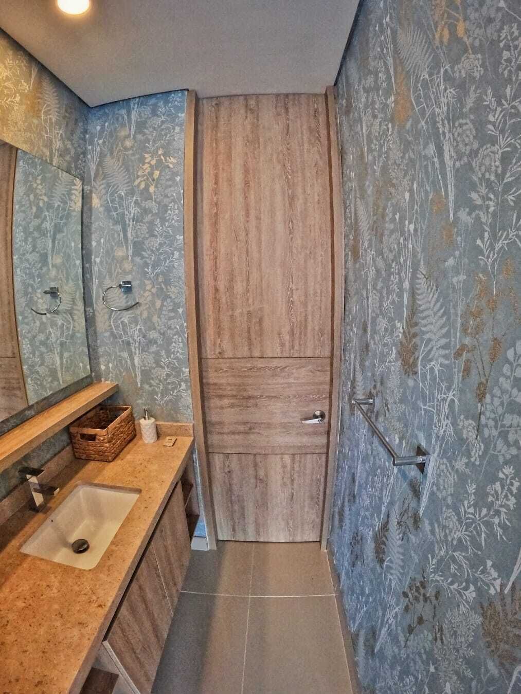 A bathroom with a wooden vanity, a large mirror, and a shower area.