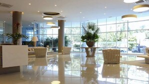 A spacious lobby with a polished floor, large windows, and several potted plants. - Reserva del Mar Apartamentos (Santa Marta)