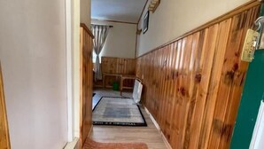 A narrow hallway with wooden paneling on the walls and a rug on the floor. - Panorama Lodge and Restaurant  (Namche Bazar)