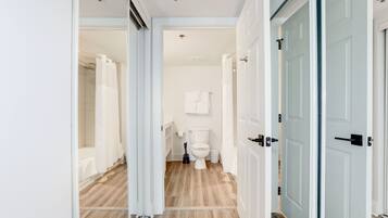 Een moderne badkamer met toilet, douche en een wit kastje.