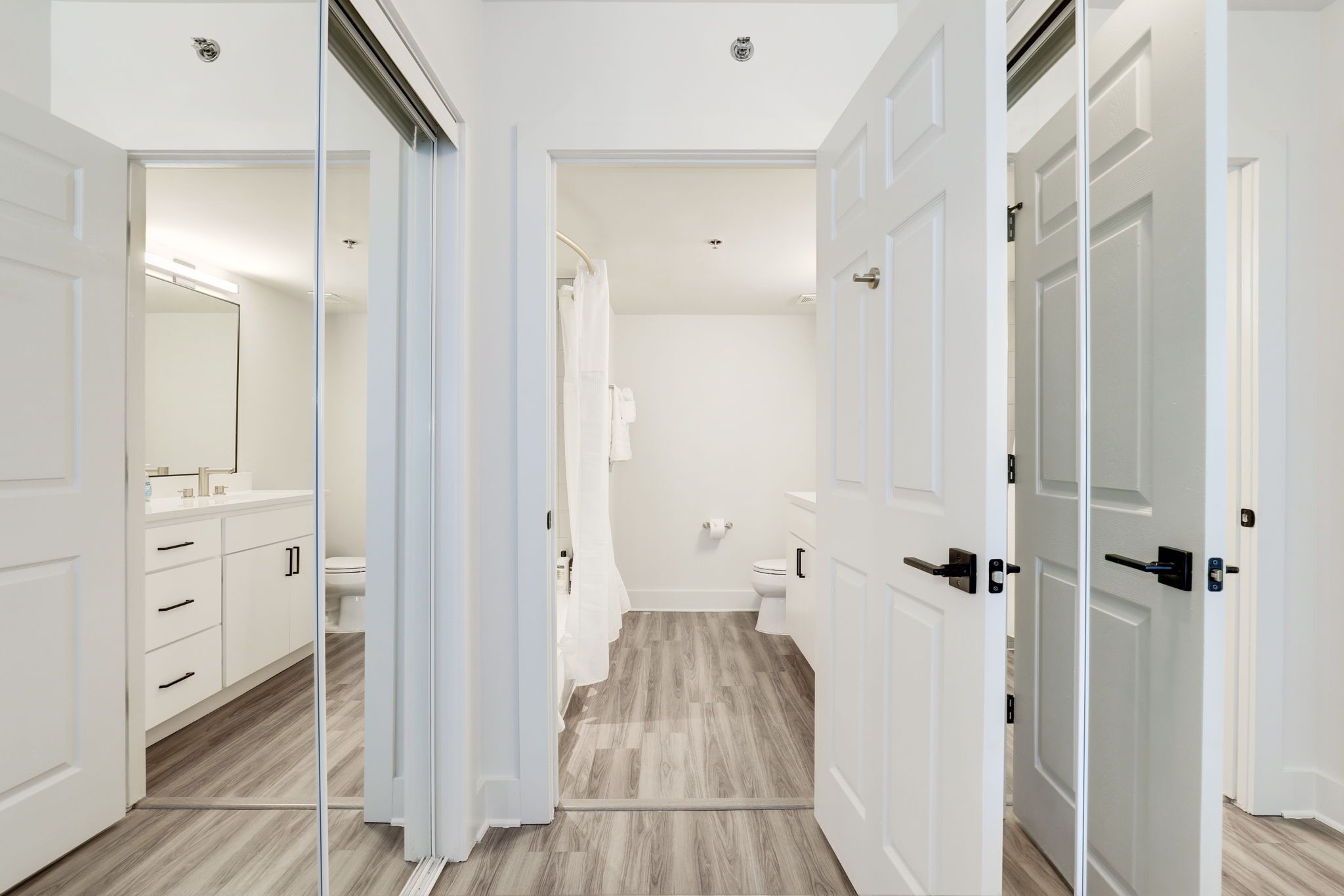Een moderne badkamer met douche, toilet en wastafel.
