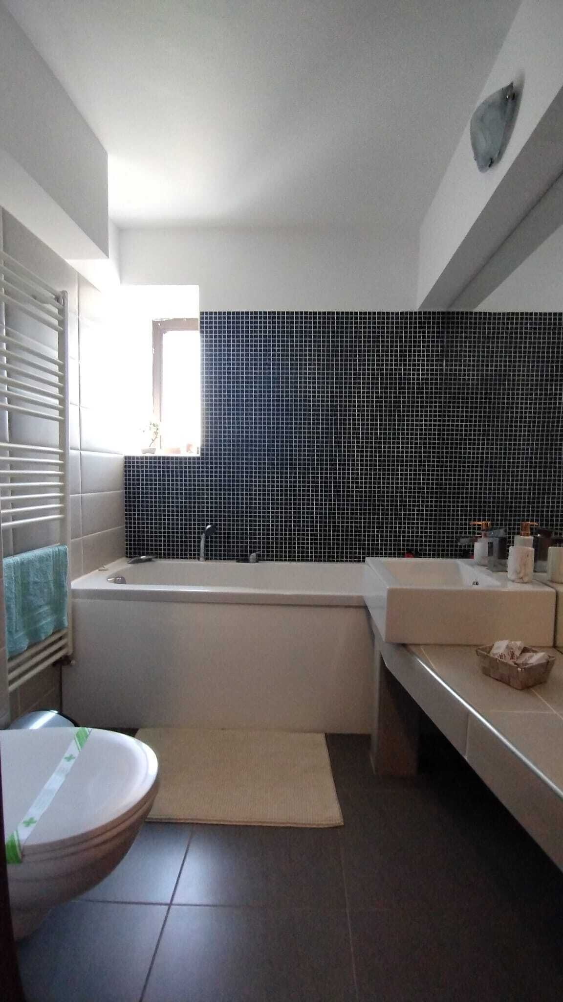 Un baño con bañera, lavamanos e inodoro.
