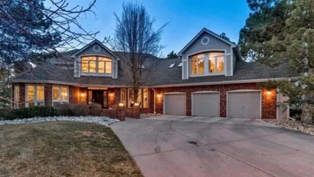 A two-story house with a garage, a driveway, and a well-maintained lawn. - Beautiful 5BR home on 1 acre in Highlands Ranch perfect for families (Littleton)