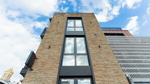 Un edificio moderno con un ventanal vertical llamativo y fachada de ladrillo.