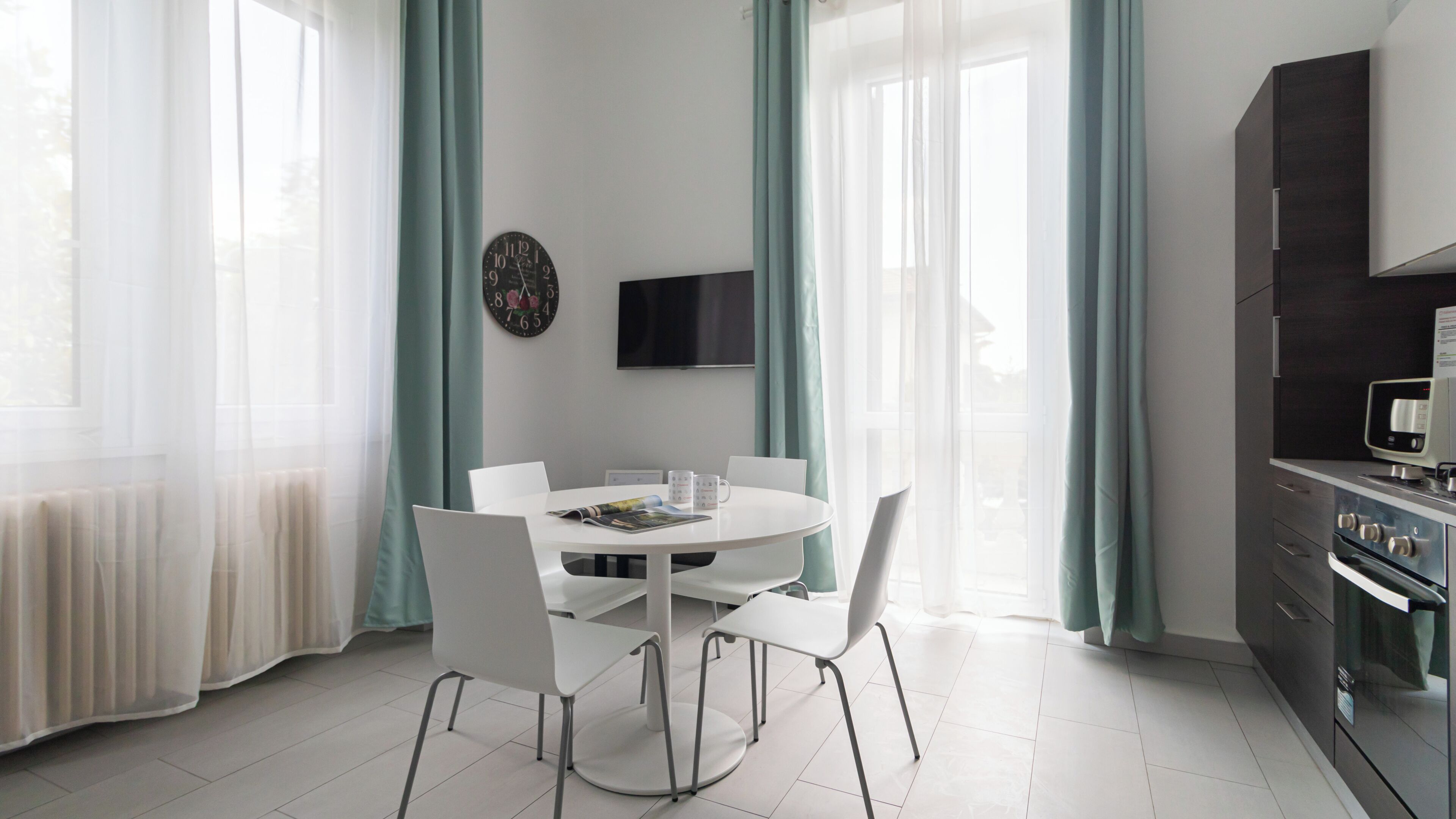 A modern kitchen with white cabinetry, a built-in oven, and a microwave.