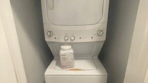 Une petite buanderie équipée d’un lave-linge et d’un sèche-linge superposés.