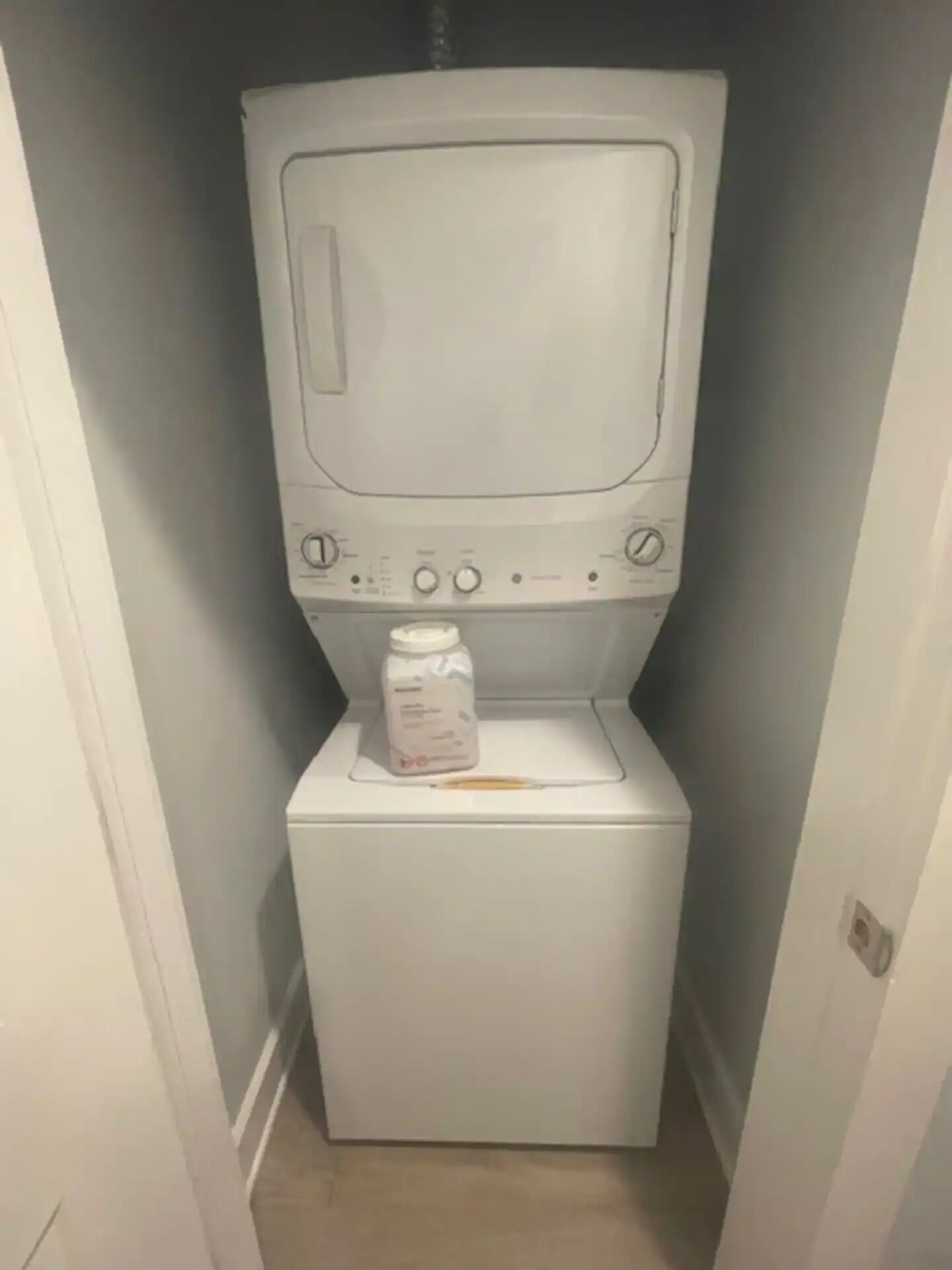Ein kleiner Hauswirtschaftsraum mit vertikal gestapelten Waschmaschine und Trockner.