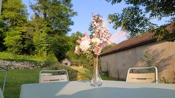 Ein Tisch mit einer Blumenvase in einem Garten.