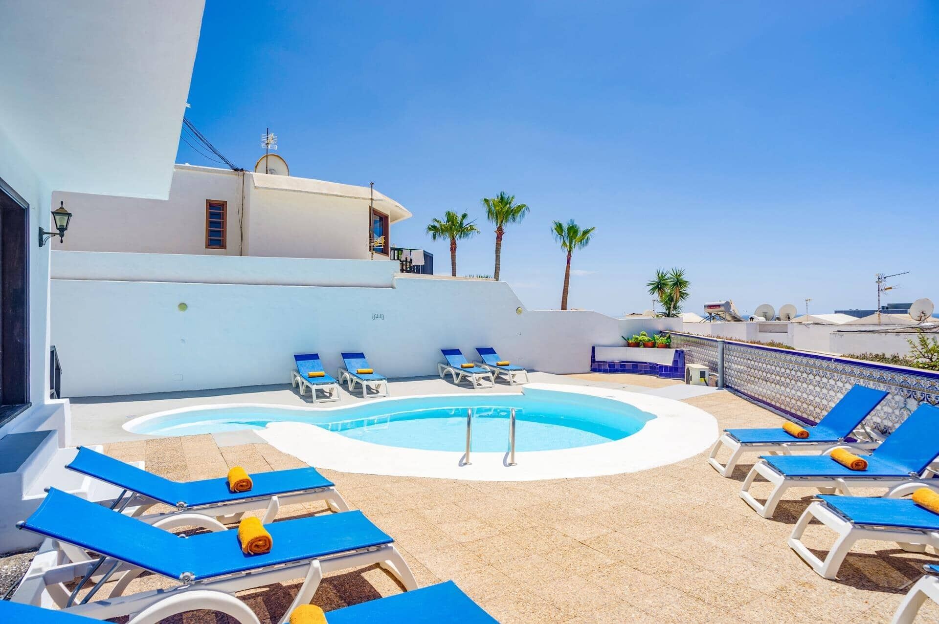 Uma área de piscina no terraço com espreguiçadeiras e piscina.