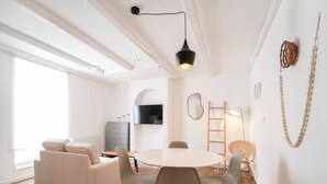 A modern living room with a round dining table, beige sofas, and a wooden floor. - Le cosy de Keller - Nancy Centre (Nancy)