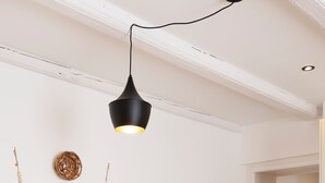 A dining area with a round table, four chairs, a pendant light, a wall-mounted decorative item, and a door leading to another room. - Le cosy de Keller - Nancy Centre (Nancy)