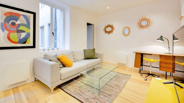 A modern living room with a sofa, a glass coffee table, and a desk with a chair. - Le Cachet de la Craffe - Au cœur de Nancy (Nancy)