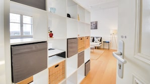 A modern interior with white shelving units, wicker baskets, and a minimalist decor. - Le Cocon des Ponts - Studio 29 m² à Nancy (Nancy)