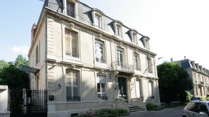 A two-story building with a symmetrical facade, large windows, and a central entrance with steps. - L'Hôtel Particulier - L'appartement de Pierre (Nancy)