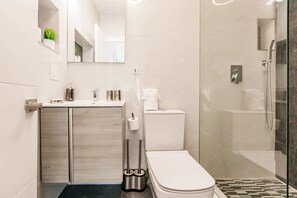 A modern bathroom with a toilet, sink, and shower. - Uhost AI Miami 5BR Heated Pool Hot Tub (Aventura)