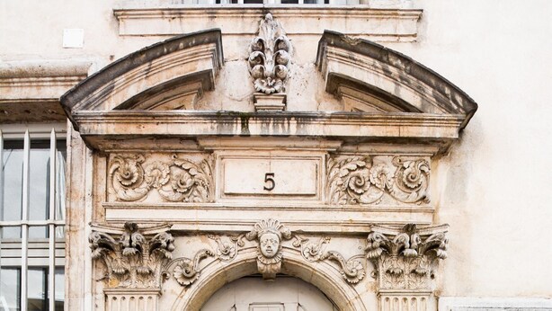 A classical building facade with a central arched door, ornate carvings, and a number '5' above the door. - Le cocon des Deux Sirènes - Studio cosy pour 2 à Nancy (Nancy)