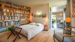Um quarto aconchegante com uma grande estante de livros, uma cama e vista para a sala de estar.