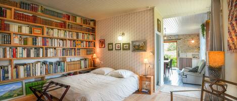 Un dormitorio acogedor con una amplia estantería, una cama y vistas al salón.