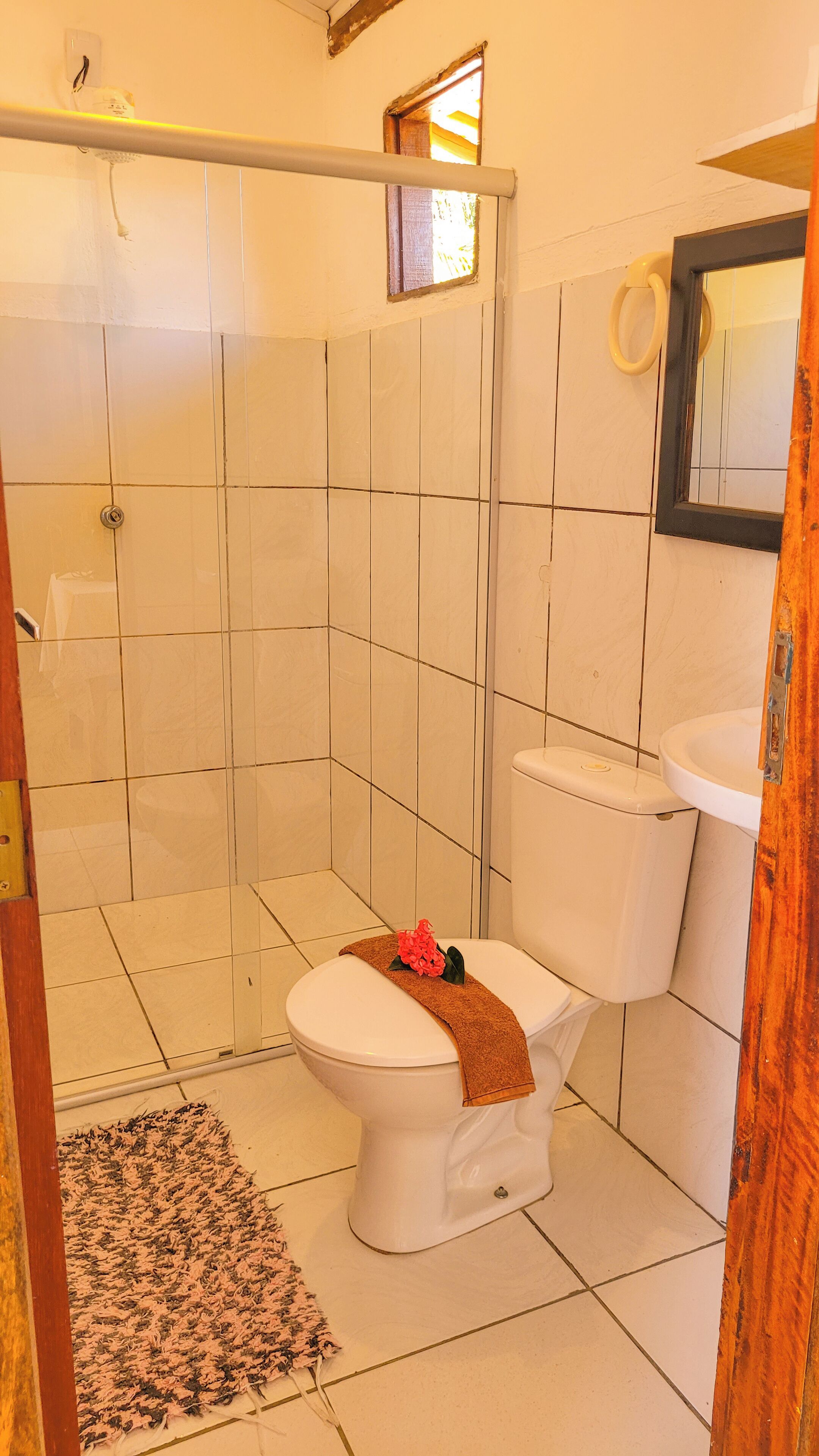 Un baño con inodoro, lavamanos y zona de ducha.