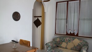 A dining area with a wooden table, chairs, and a glass cake stand.