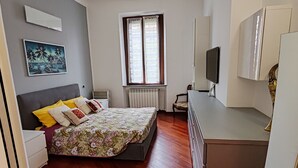 A bedroom with a bed, a desk, a chair, a radiator, and a window. - Cozy 1-bedroom apartment in fantastic Milano with AC, WiFi (Milano)