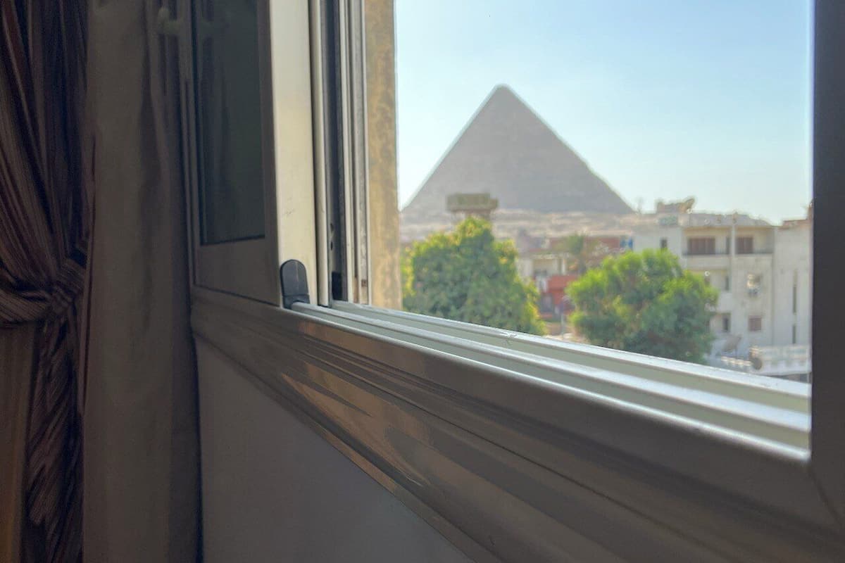 A window with a view of a pyramid and buildings.